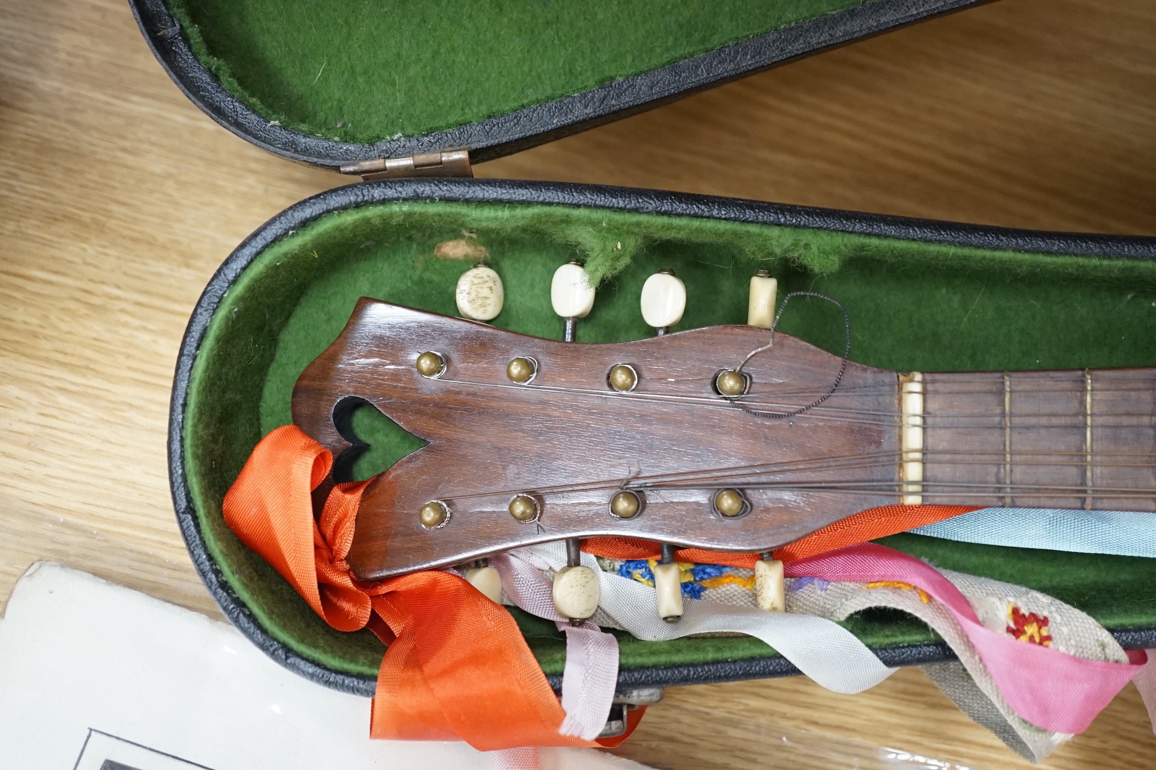 A cased late 19th/early 20th century Italian lute back mandolin with segmented rosewood back and spruce top, eight brass and bone pegs, 60.5cms high